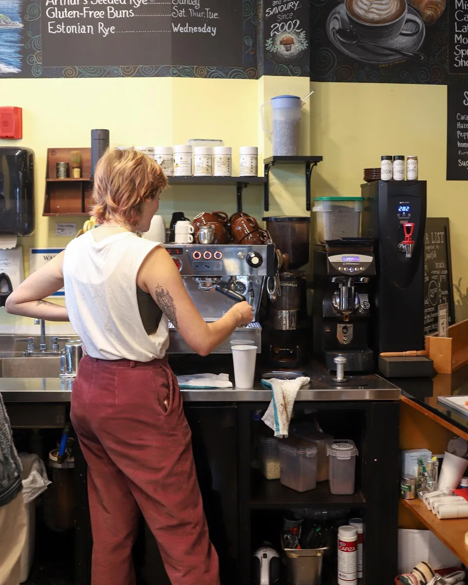 A barista preparing coffee behind the counter