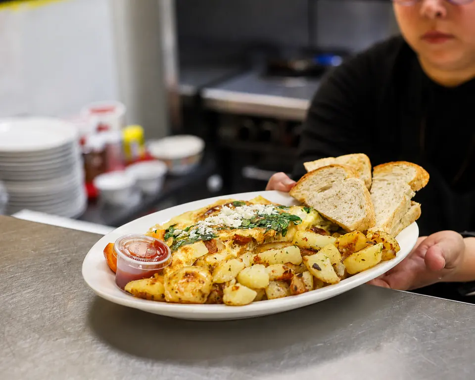 A breakfast plate with eggs, potatoes and toast