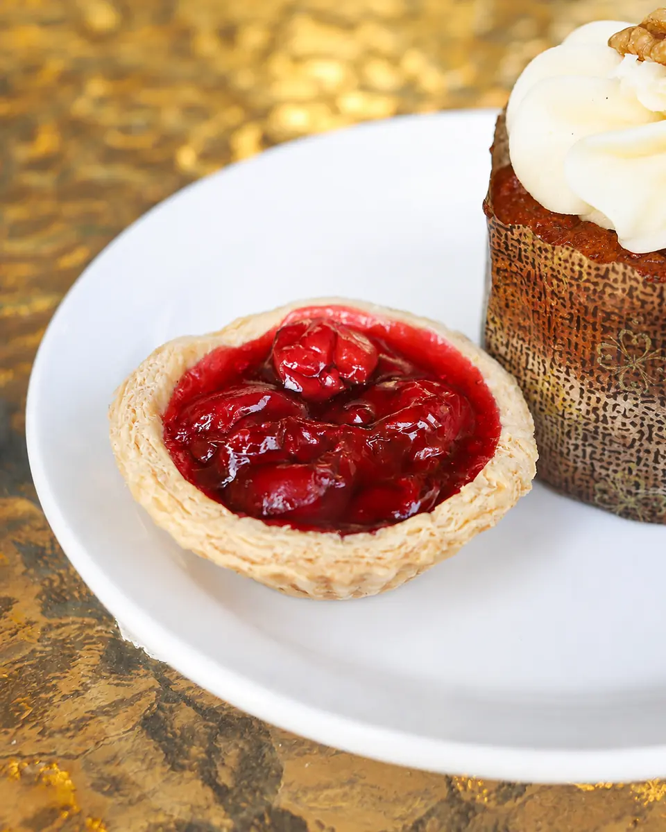 A red fruit tart on a white plate